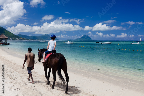Promenade à cheval sur la plage de flic en flac à l'ile Maurice photo