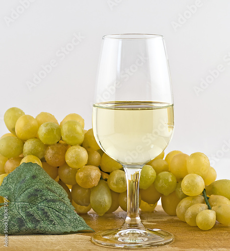 vino bianco in calice con uva