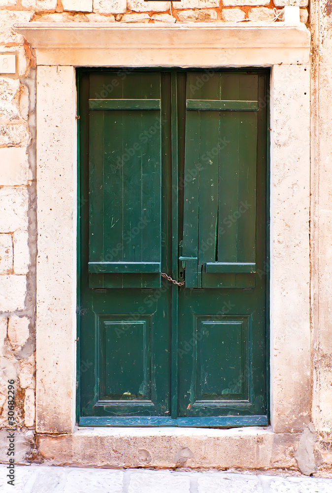 Green wooden doors in Dubrovnik, mediterranean town on the coast