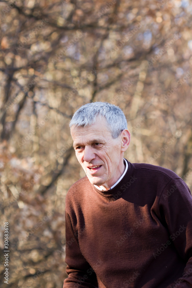 nice elderly white-haired man in a autumn park