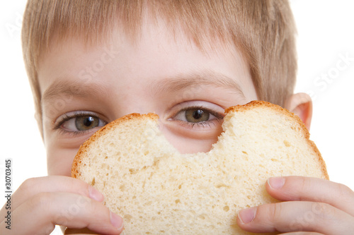 Boy looking through piece of bread
