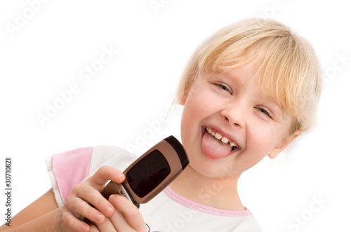 little girl with a mobile phone shows his tongue