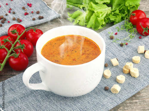 Fotografie Tomato soup with fresh ingredients in a soup cup