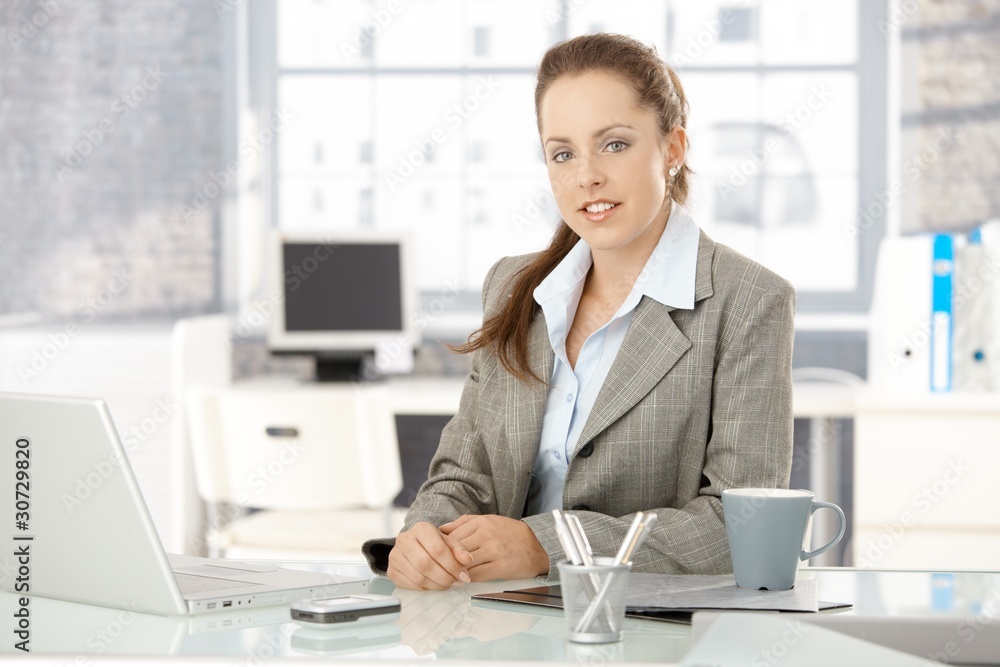 Young businesswoman sitting in bright office Young businesswoman sitting in bright office