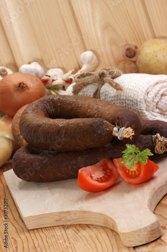 rohe Grützwurst auf einem Holzteller photo