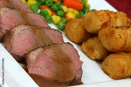 Entenbrust geschnitten mit Kroketten und Gemüse photo