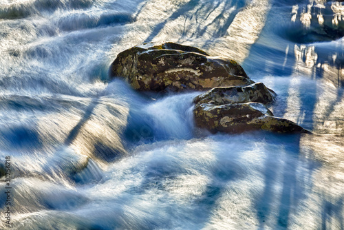 Photography Raging river flows around rocks