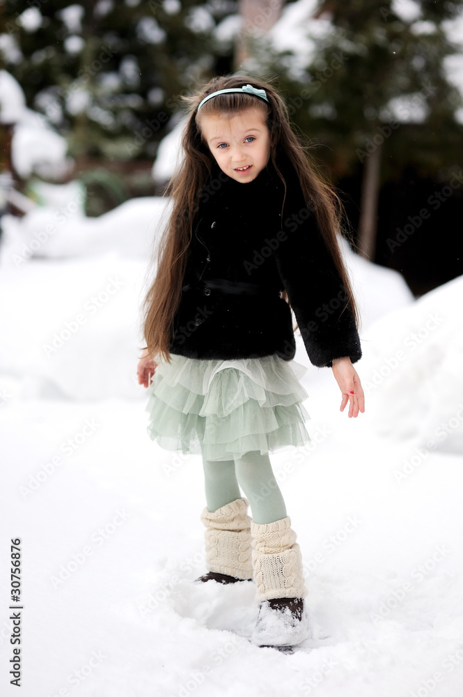 Adorable little girl in green tutu dances outside in snow Adorable little girl in green tutu dances outside in snow