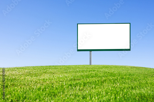 Blank billboard on green field