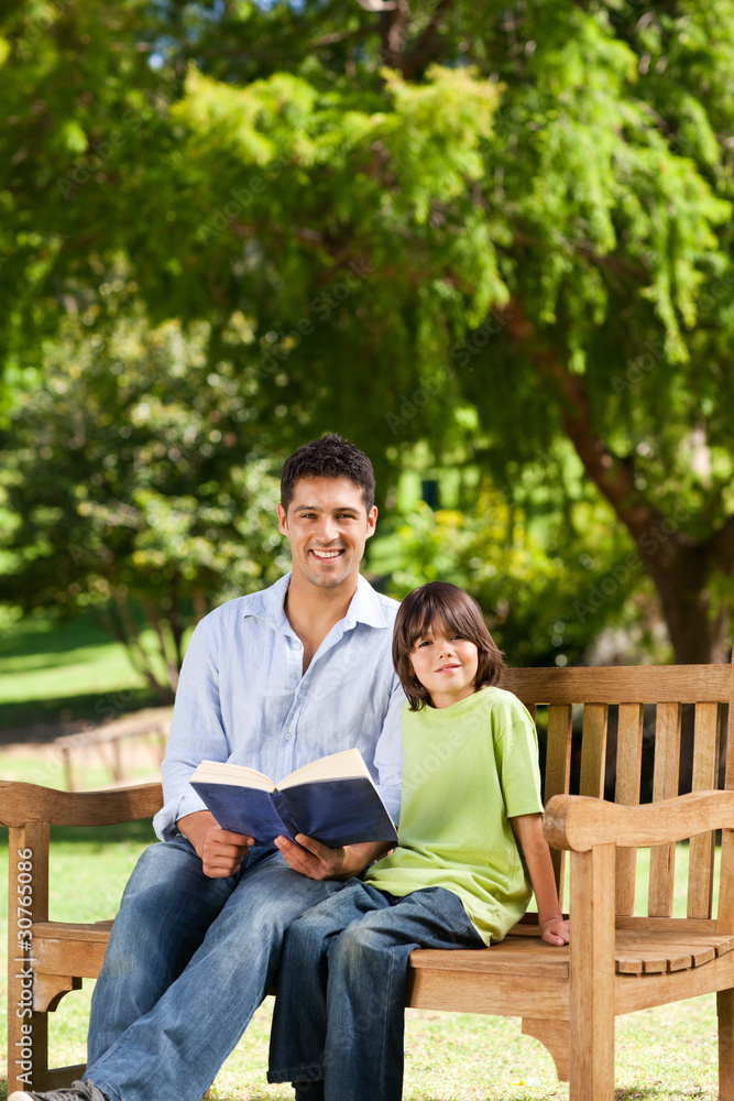 Fototapeta premium Son with his father reading a book