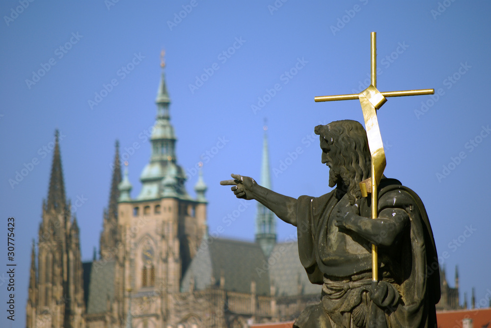 Fototapeta premium Heiligenstatue in Prag mit dem Dom im Hintergrund