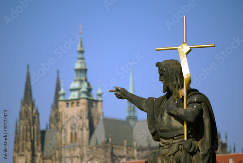 Heiligenstatue in Prag mit dem Dom im Hintergrund photo