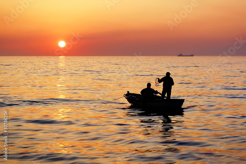 Fisherman boat on sunset