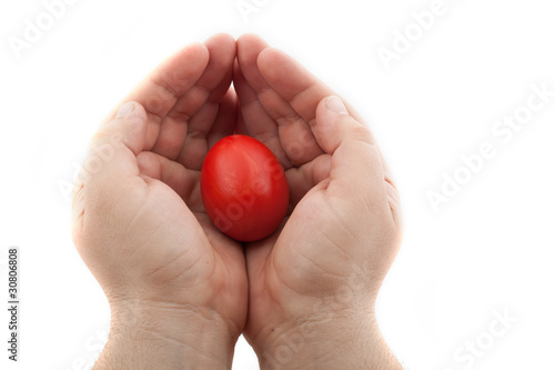 red easter egg holded in hands with care