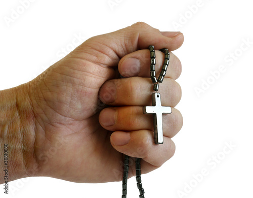 hand holding a cross on a chain