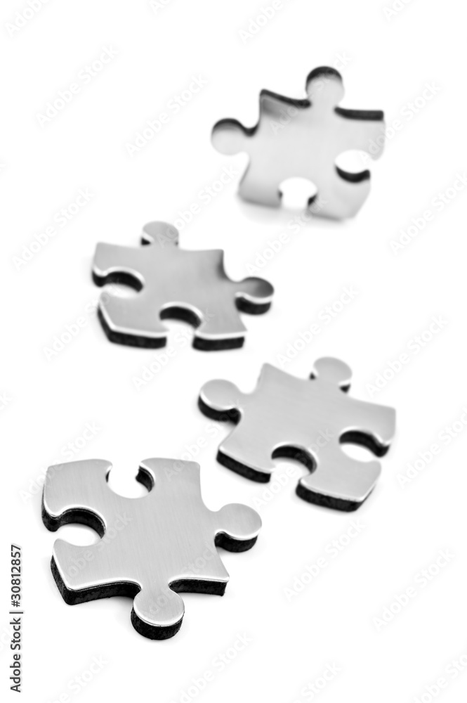 Stainless steel puzzles pieces on white background Stainless steel puzzles pieces on white background