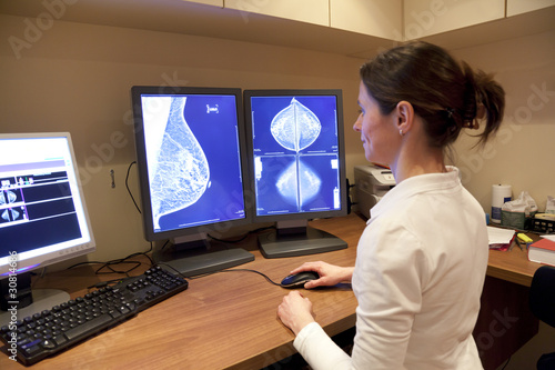 Radiology technician looking at mammography photo