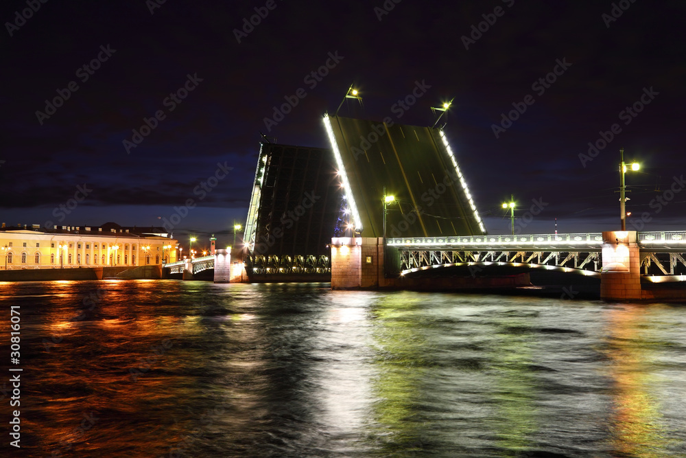 Palace Bridge drawbridge on Neva river at night.