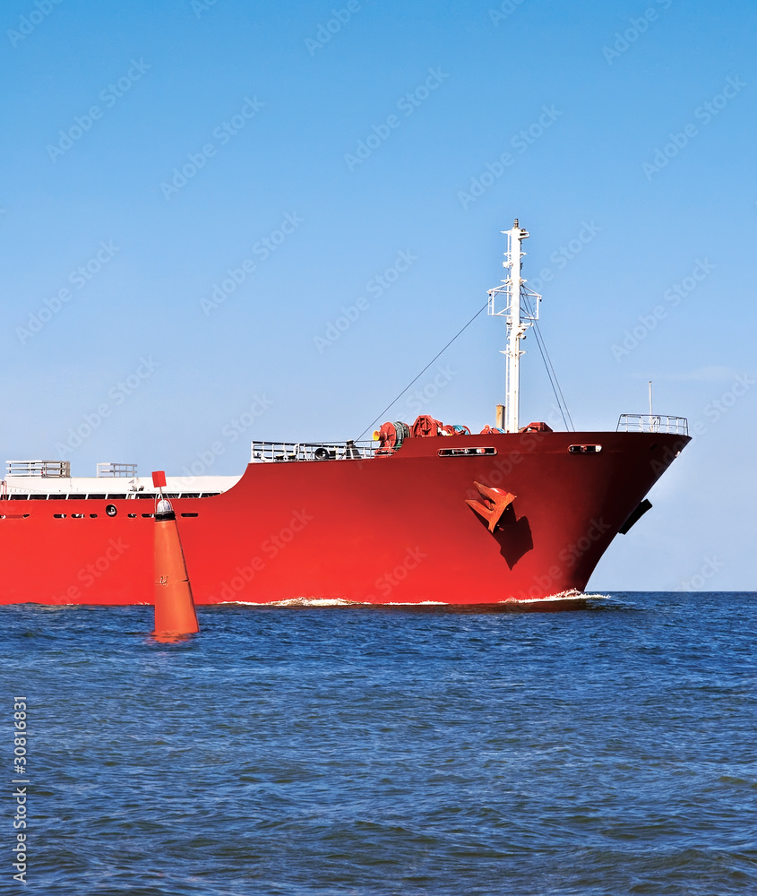 Obraz premium Bow of the red ship in the ocean and a red buoy.