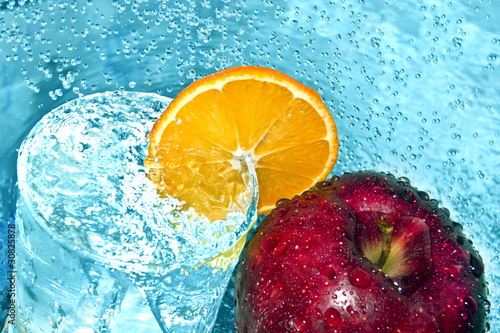 Fototapeta Naklejka Na Ścianę i Meble -  Apple and orange in water drops