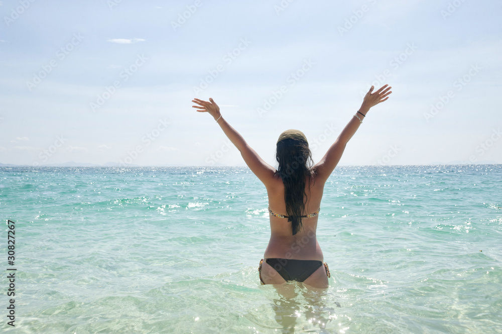 Happy young woman in sea with open hands and jump,Maya Bay, Koh Happy young woman in sea with open hands and jump,Maya Bay, Koh