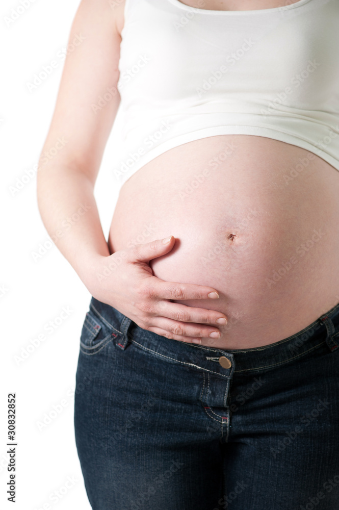 pregnant woman holding her belly with one hand on white pregnant woman holding her belly with one hand on white