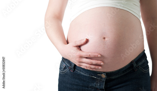 pregnant woman holding her belly with one hand on white © ventura