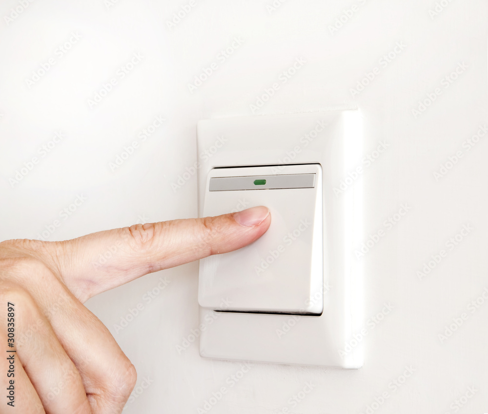 Doigt sur un interrupteur électrique Doigt sur un interrupteur électrique