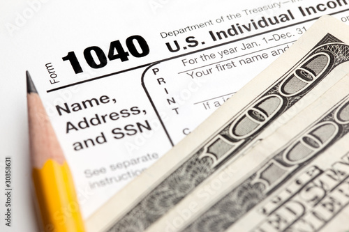 Tax time - Closeup of U.S. 1040 tax return with pencil and money