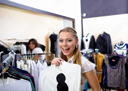young woman in a shop buying clothes