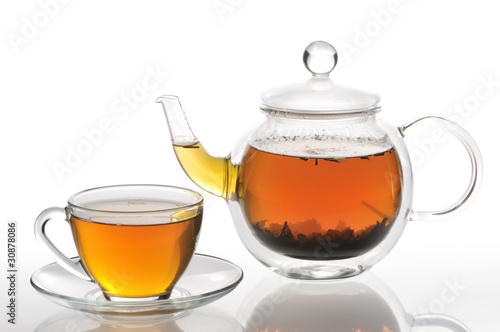 Cup and teapot with green tea on a white background