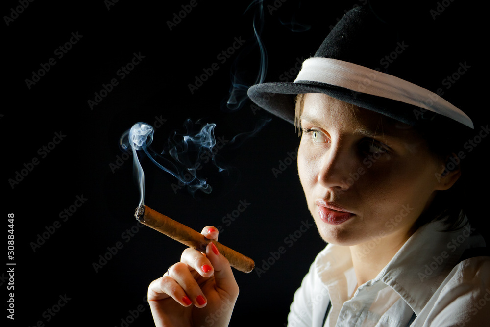 Fototapeta premium Woman in black hat with cigar