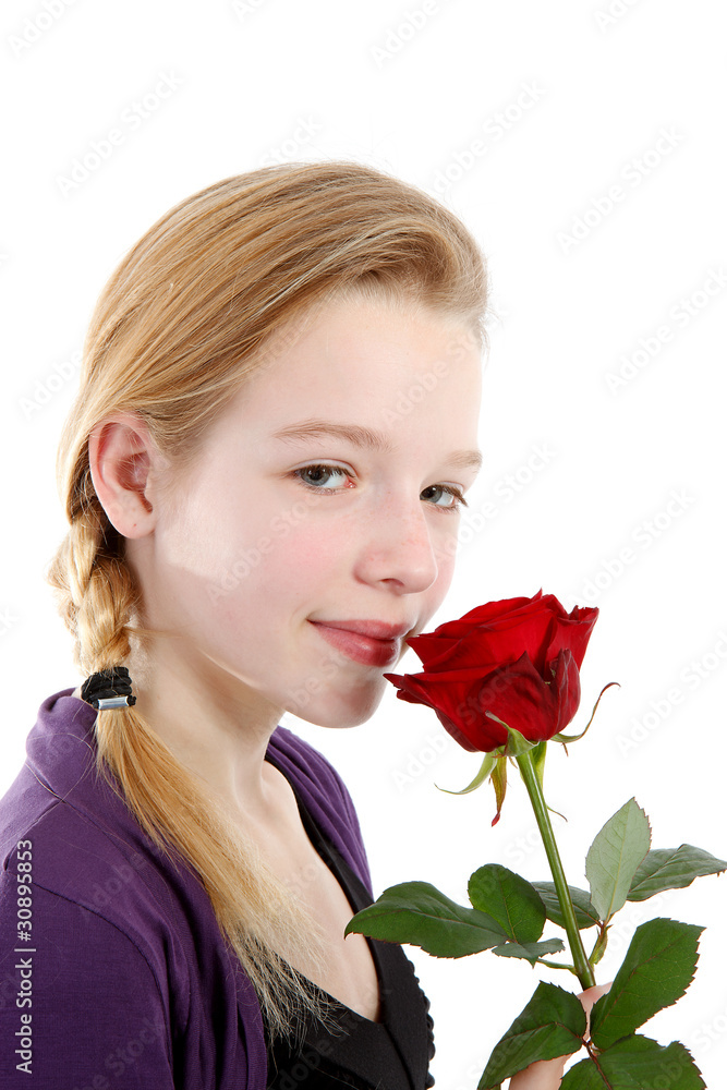 young girl smelling a red rose in closeup young girl smelling a red rose in closeup