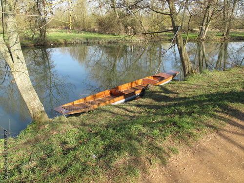 Empty punt moored on a tranqil river bank photo
