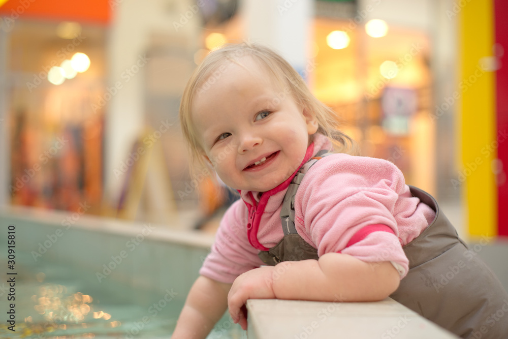 young adorable girl playing in a public fountain in mall young adorable girl playing in a public fountain in mall