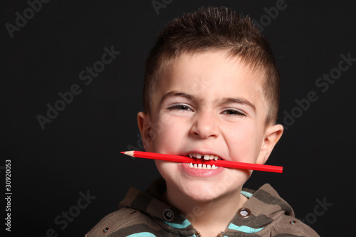 bambino con matita rossa in bocca photo