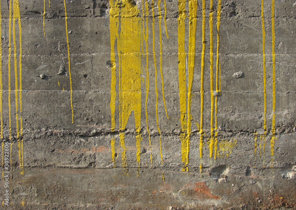 dirty gary industrial concrete wall with fat yellow paint drips