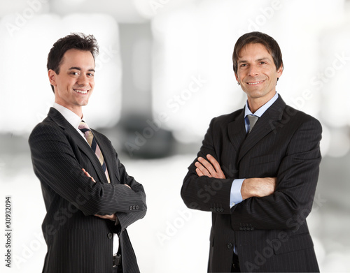 Two businessmen smiling. Soft background. photo