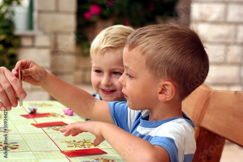 Children play a board game, one takes a card