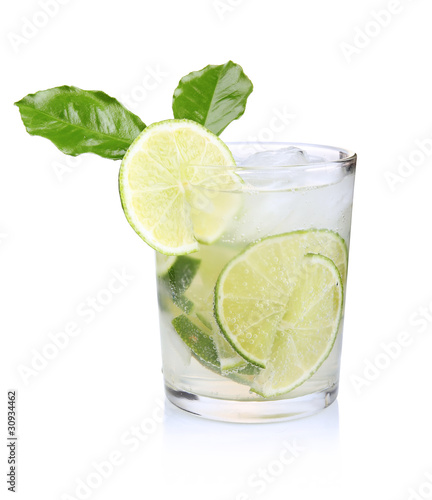 Full glass of fresh cool tonic with lime fruits isolated