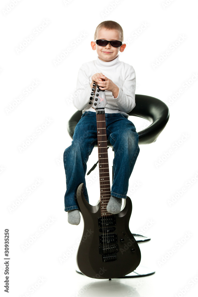 Cute little boy holding a guitar