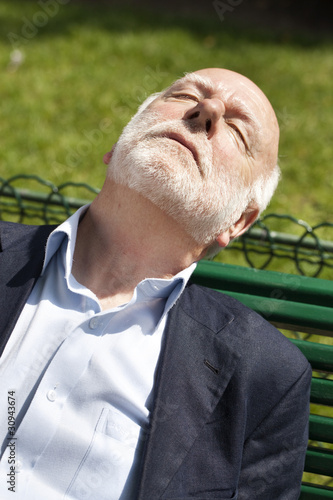 vieil homme assoupi dans un parc photo