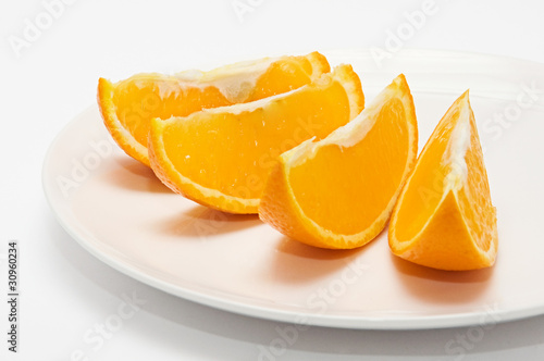 four orange slices on white plate isolated