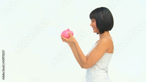 Lovely asian lady saving up money in a piggy bank photo