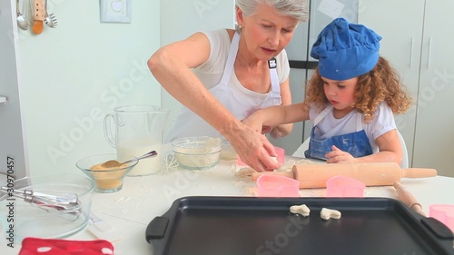 Grandmother an dher grand daughter cooking together photo