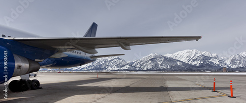 View of the teton range under an airplane wing