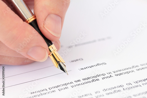 Hand with Fountain Pen Signing a Document
