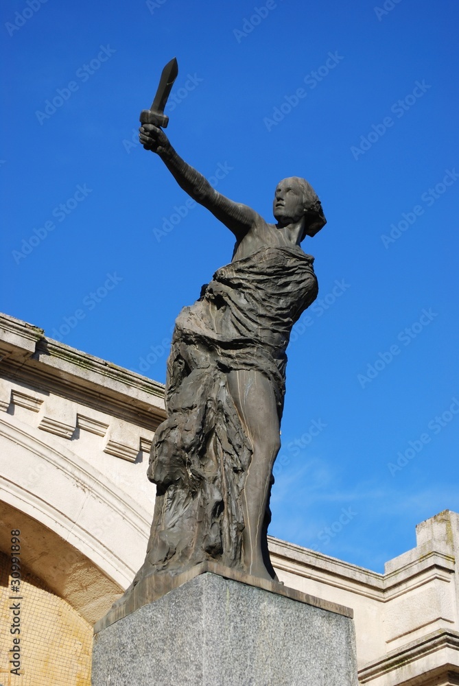 Woman's bronze statue on blue sky, Italy