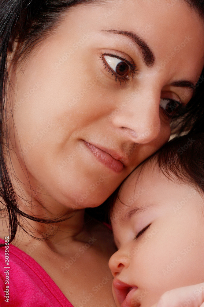 Young mother hugging her baby while sleeping Young mother hugging her baby while sleeping