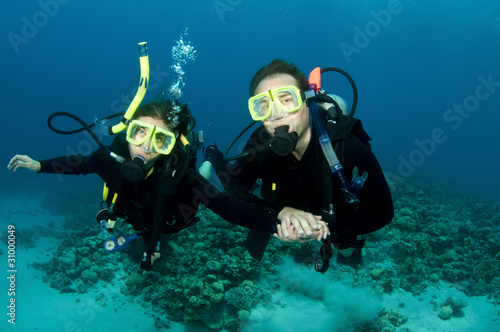 happy couple scuba dive together